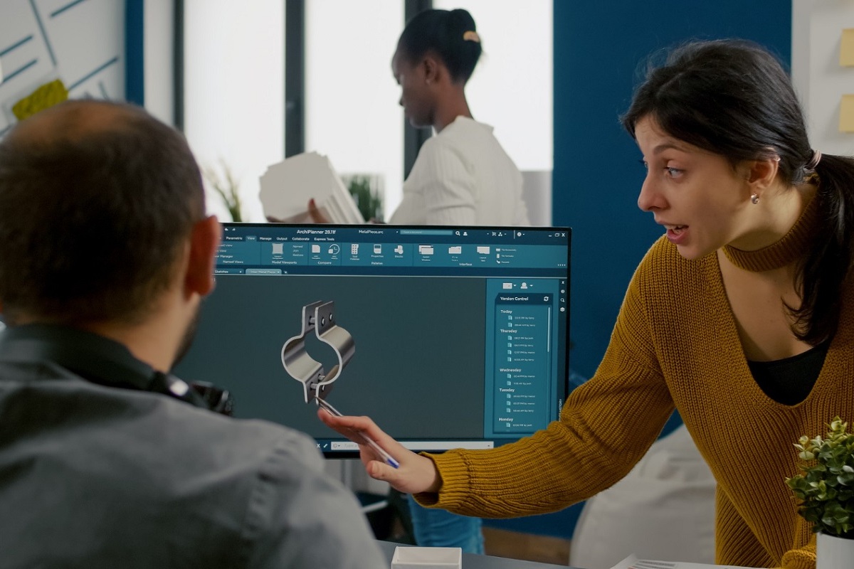 Imagem de pessoas conversando em frente a um computador e conversando sobre o que aparece na tela