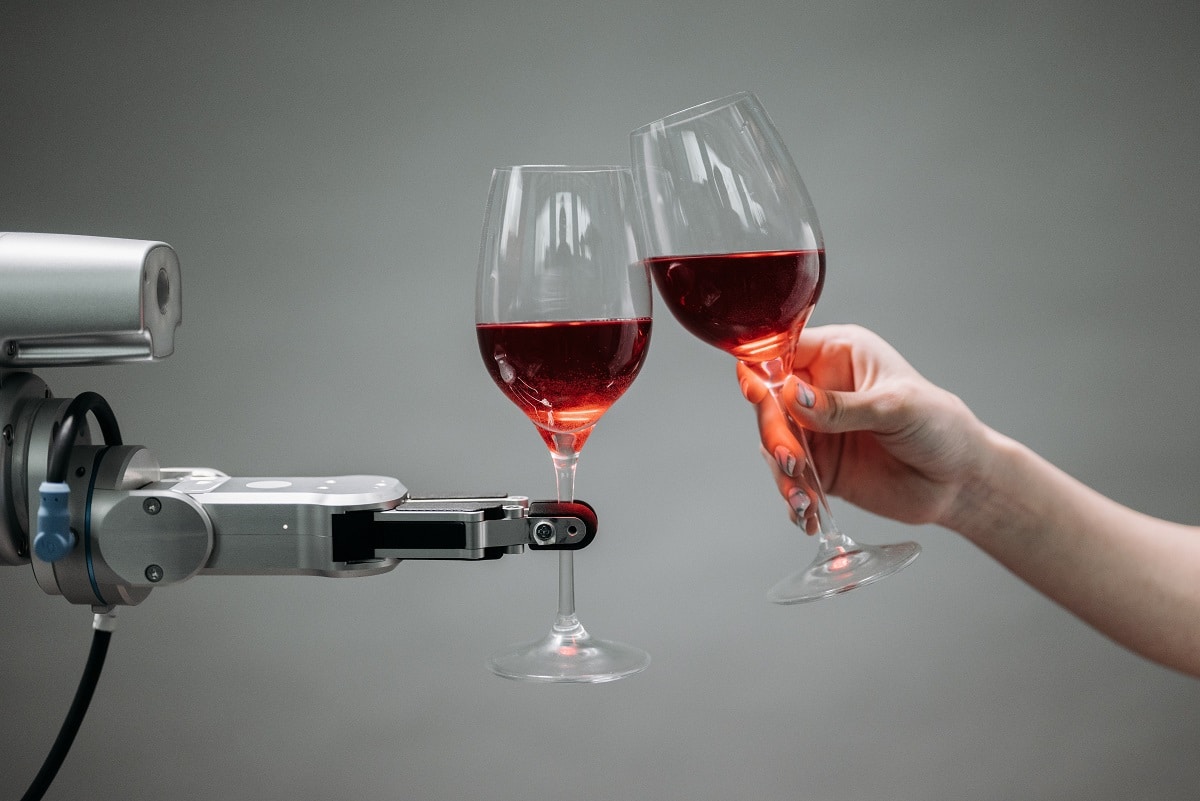 robô e uma pessoa, ambos segurando uma taça de vinho