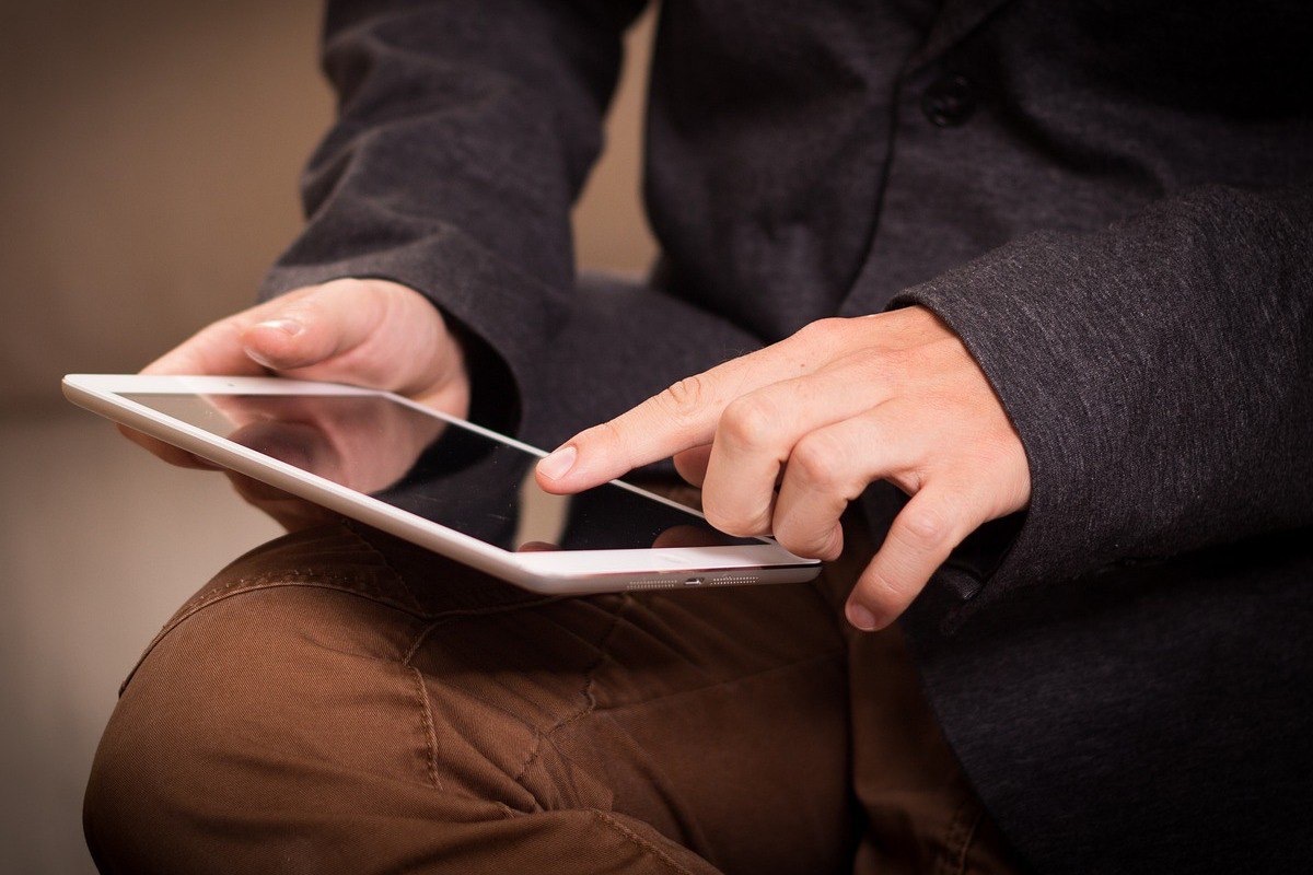 pessoa sentada, usando um tablet