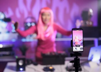 Uma artista com cabelo rosa fazendo uma live NPC no TikTok