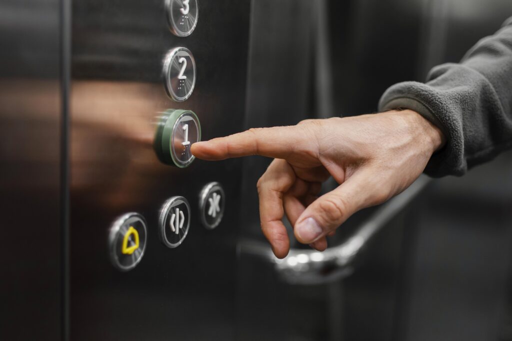 Uma pessoa pressionando o botão 1 de um elevador
