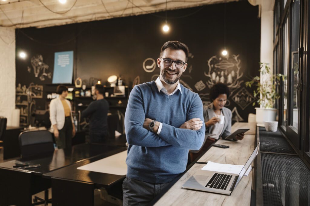 Um empresário de sucesso ao lado de um laptop no café