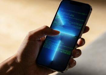 Stylized figure using a smartphone with abstract digital terminal session and glowing file icons, deep blue background.