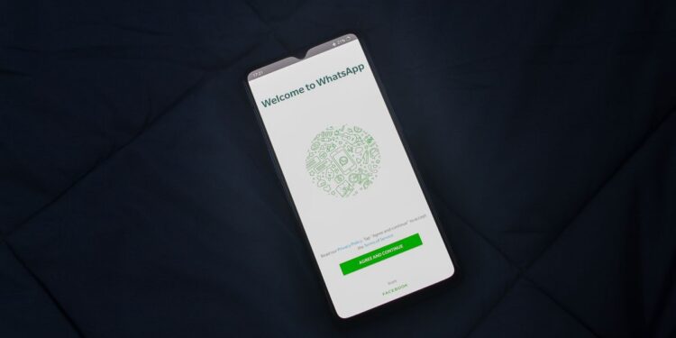 WhatsApp libera reserva de nomes de usuário e abre caminho para dispensar o número nas conversas 28 Smartphone exibindo a tela de boas-vindas do WhatsApp sobre tecido azul-marinho escuro