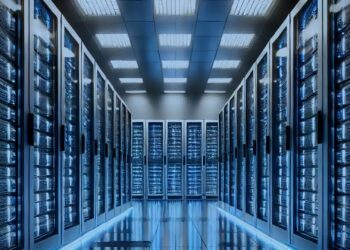 Datacenter corredor de racks com LEDs azuis, paleta azul-marinho e ciano — capa do caso JadePuffer (Sysdig, junho 2026). Imagem: DALL·E 2025-01-31 / Wikimedia Commons (CC BY-SA 4.0).