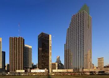 Skyline de Buenos Aires ao entardecer, com prédios empresariais ao fundo e grama em primeiro plano