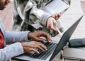 Estudantes usando notebook e anotações para estudar