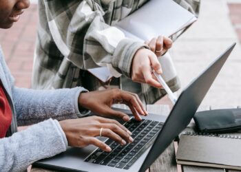 Estudantes usando notebook e anotações para estudar