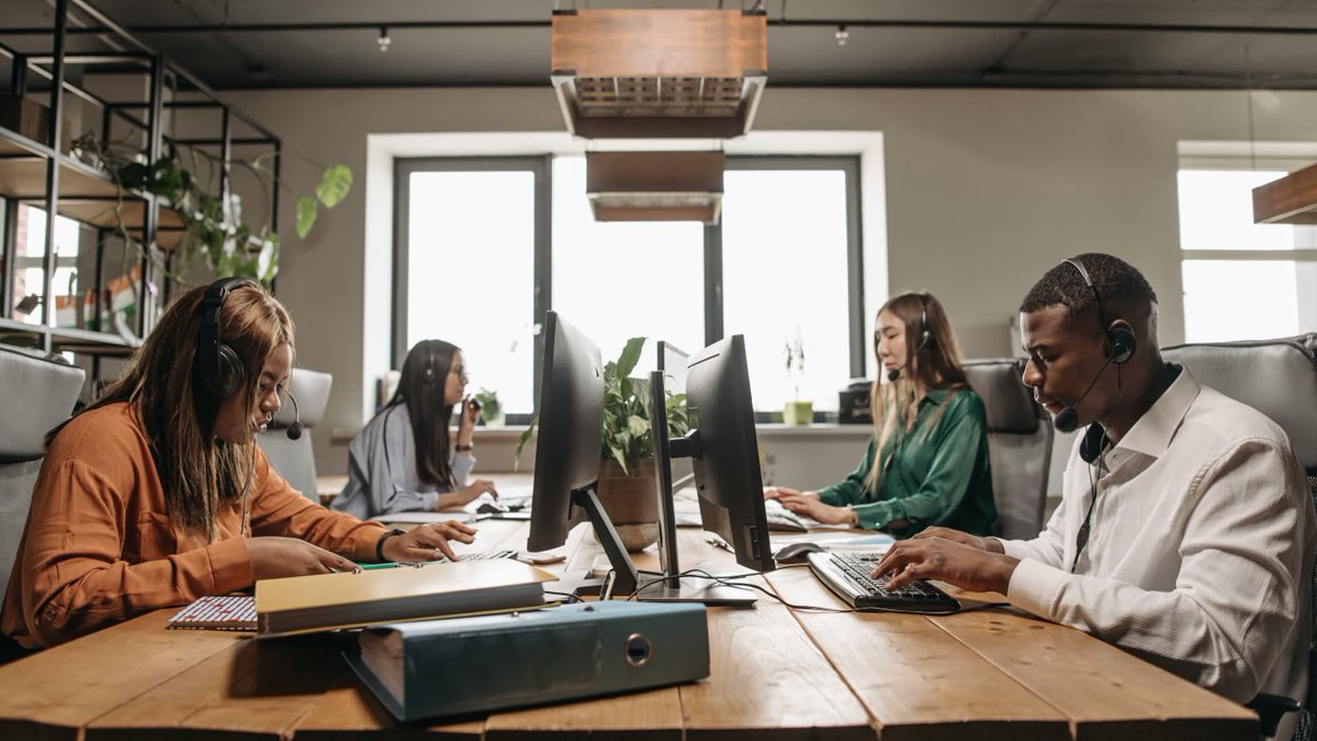 Equipe trabalha em computadores em escritório contemporâneo